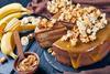 A banana cake topped with caramel sauce and popcorn