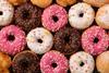Ring doughnuts topped with chocolate, pink and white icing and sprinkles