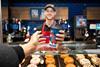 Greggs - Worker serves a coffee to a customer during the festive period