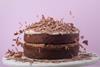 A gluten-free chocolate layer cake with a heavy sprinkle of chocolate flakes on top