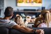 A family with two children watching TV