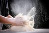 A pile of flour being clapped by a baker