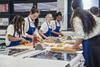 Teenagers making pizza in a classroom