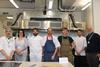 Plumpton College - Food Industry Skills programme manager Anthony Gaston (right) and bakery lecture Aidan Chapman (left) stand with the Level 3 Lead Baker apprentices in the training kitchen - 2100x1400