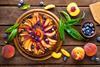 A lovely looking peach & blueberry tart on a wooden board