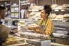 Getty Images -1451382673 woman serving customer at counter credit sanjeri