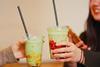 Two young women drinking iced matcha