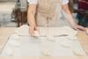 A woman placing raw croissant dough onto a baking tray