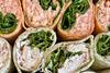A selection of wraps filled with salad, chicken, and cheese