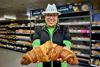 An Asda worker holding a giant croissant