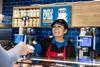 Greggs staff member serves a customer at a store in Cobham, Surrey  2100x1400