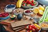 A selection of healthy foods including rye bread, fruits, vegetables, and nuts