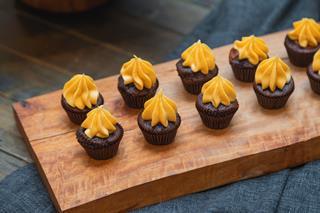 Mini Chocolate Cupcakes with Orange Frosting on Rustic Wooden Serving Board