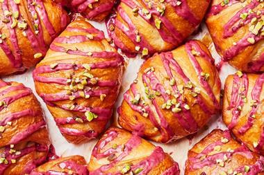 Close-up of Blackberry Bliss dough drizzled with blackberry icing and topped with pistachios