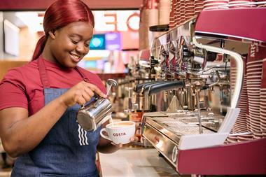 Costa employee pouring frothy milk into a mug