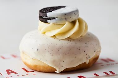 A cookies & cream flavoured doughnut with white chocolate drizzle and an Oreo on top