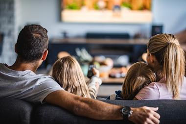 A family with two children watching TV