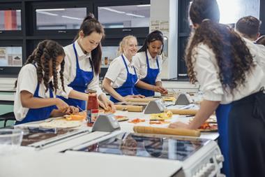 Teenagers making pizza in a classroom