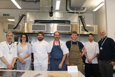 Plumpton College - Food Industry Skills programme manager Anthony Gaston (right) and bakery lecture Aidan Chapman (left) stand with the Level 3 Lead Baker apprentices in the training kitchen - 2100x1400