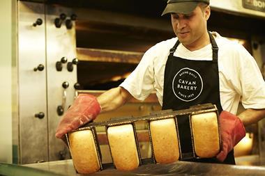 A worker empties out freshly-baked bread tins at The Cavan Bakery's new production site in Walton-on-Thames  2100x1400