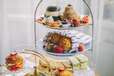 Afternoon tea stand laden with cakes, pastries, and scones