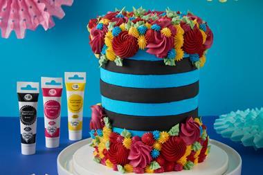 A blue and black cake with colourful swirls of frosting on
