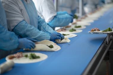 Greencore - Workers make wraps on a production line at a Greencore factory