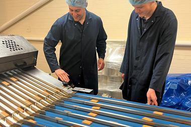 Elkes Biscuits factory service technician Aidan Fowell (left) and electrical engineer Connor Gratton check a biscuit production line  2100x1400