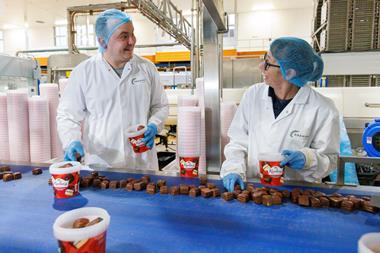 Premier Foods - Factory workers smile whilst packing tubs of Mr Kipling cake bites - 2100x1400