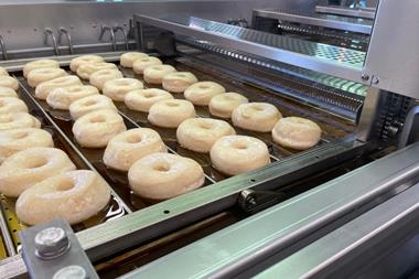 Doughnuts being fried on an industrial line