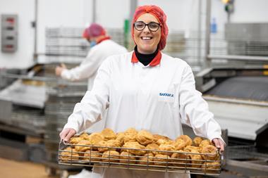 Bakkavor factory workers hold tray of bread rolls  2100x1400