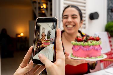 A person with a colourful cake on social media