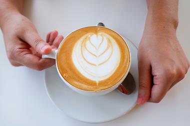A pair of hands holding a mug with a lovely latte inside