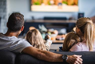A family with two children watching TV