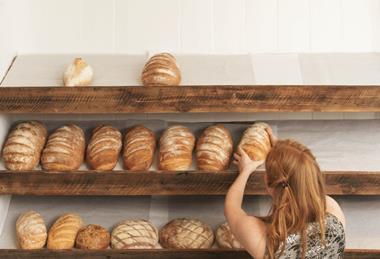 Woman stocking bakery shelves