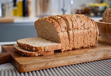 A sliced loaf with seeds on top in a modern kitchen