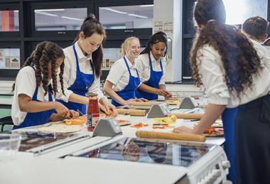 Teenagers making pizza in a classroom