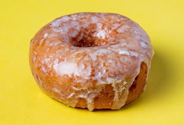 A Original Vanilla Bean Glaze Doughnut on yellow background