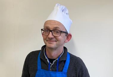 Leighton Byrom, a master baker in blue apron and white hat, at Genius Foods