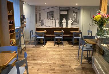 Alexander Taylor - A black and white photo of the bakery displayed on the wall of the cafe  - 2100x1400