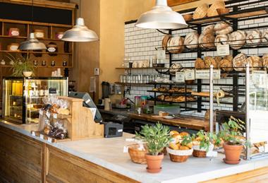 Inside a lovely looking bakery with loaves stacked on the walls