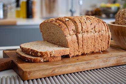 A sliced loaf with seeds on top in a modern kitchen