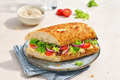 Tiger Granulat on top of a soft baguette filled with cheese and salad