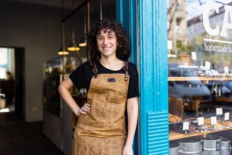 A woman with curly dark hair stood outside a bakery