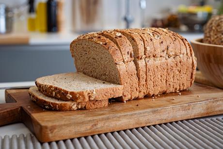 A sliced loaf with seeds on top in a modern kitchen