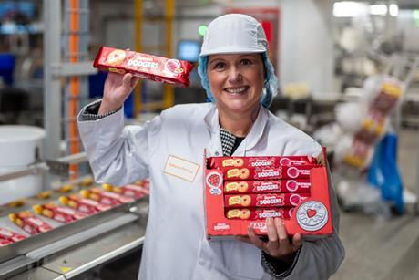Rebecca Phillips, factory manager, FBC UK in a white coat and hairnet holding several packs of Jammie Dodgers