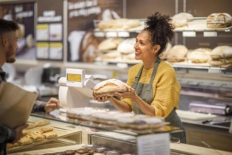 Getty Images -1451382673 woman serving customer at counter credit sanjeri