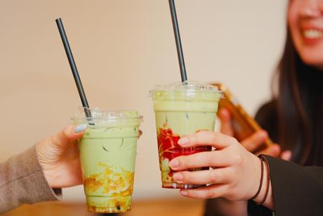 Two young women drinking iced matcha
