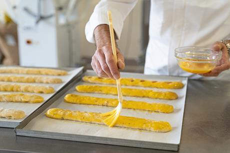 A pastry chef adding glaze to dough