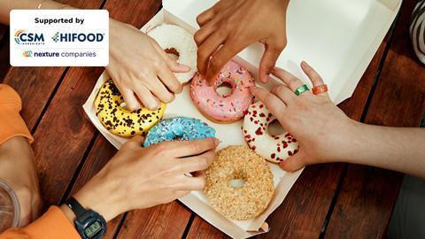 Teenagers taking doughnuts from a box